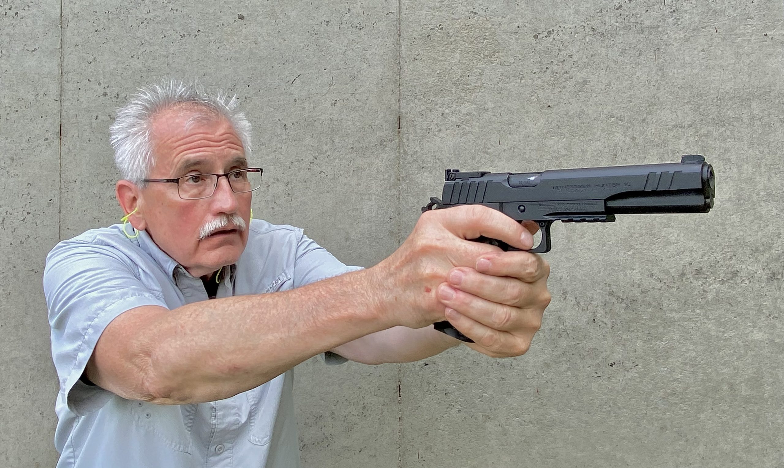 Man shooting the EAA Witness2311 Hunter 10 pistol