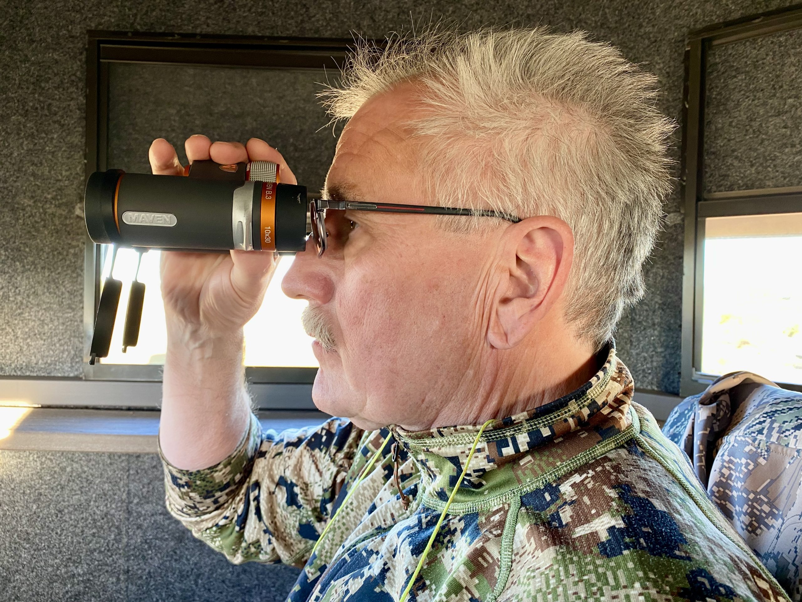 Man looking through Maven B.3 binoculars