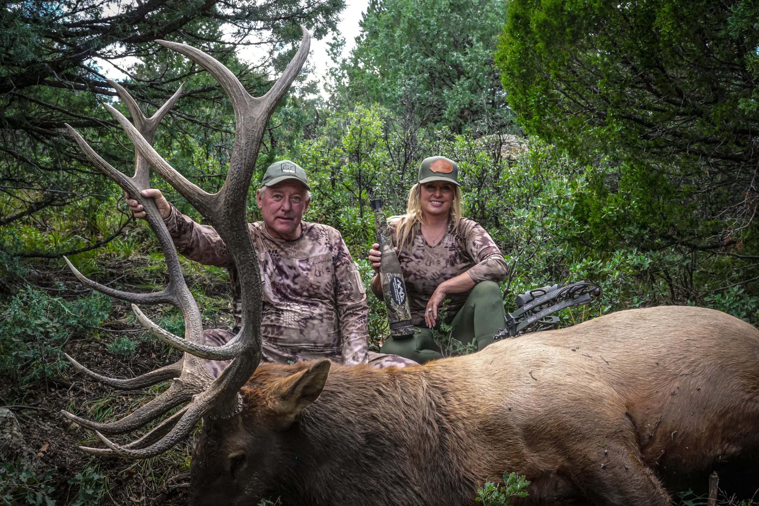 Two hunters dressed in camo with huge elk and Rocky Mountain elk call