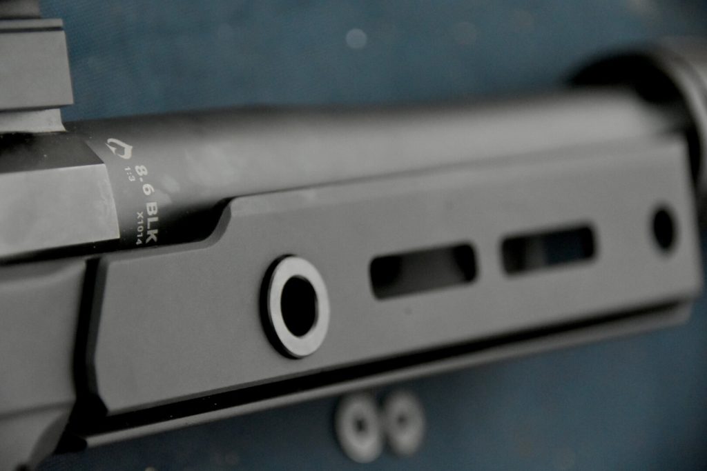 Closeup of a rifle handguard that says, "8.6 Blackout".