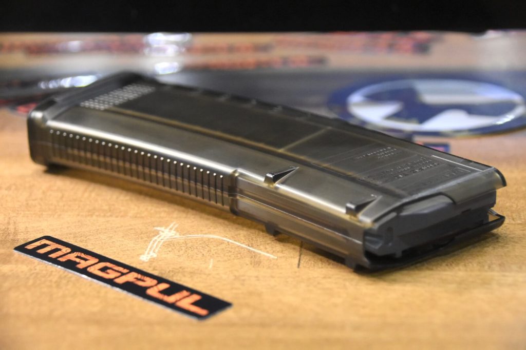 a magpul TMAG sits on the table next to Magpul's logo.