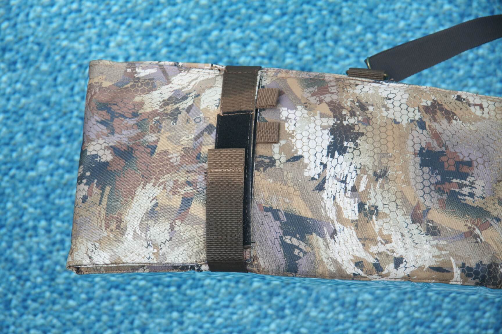 Camo end of gun case floating in water