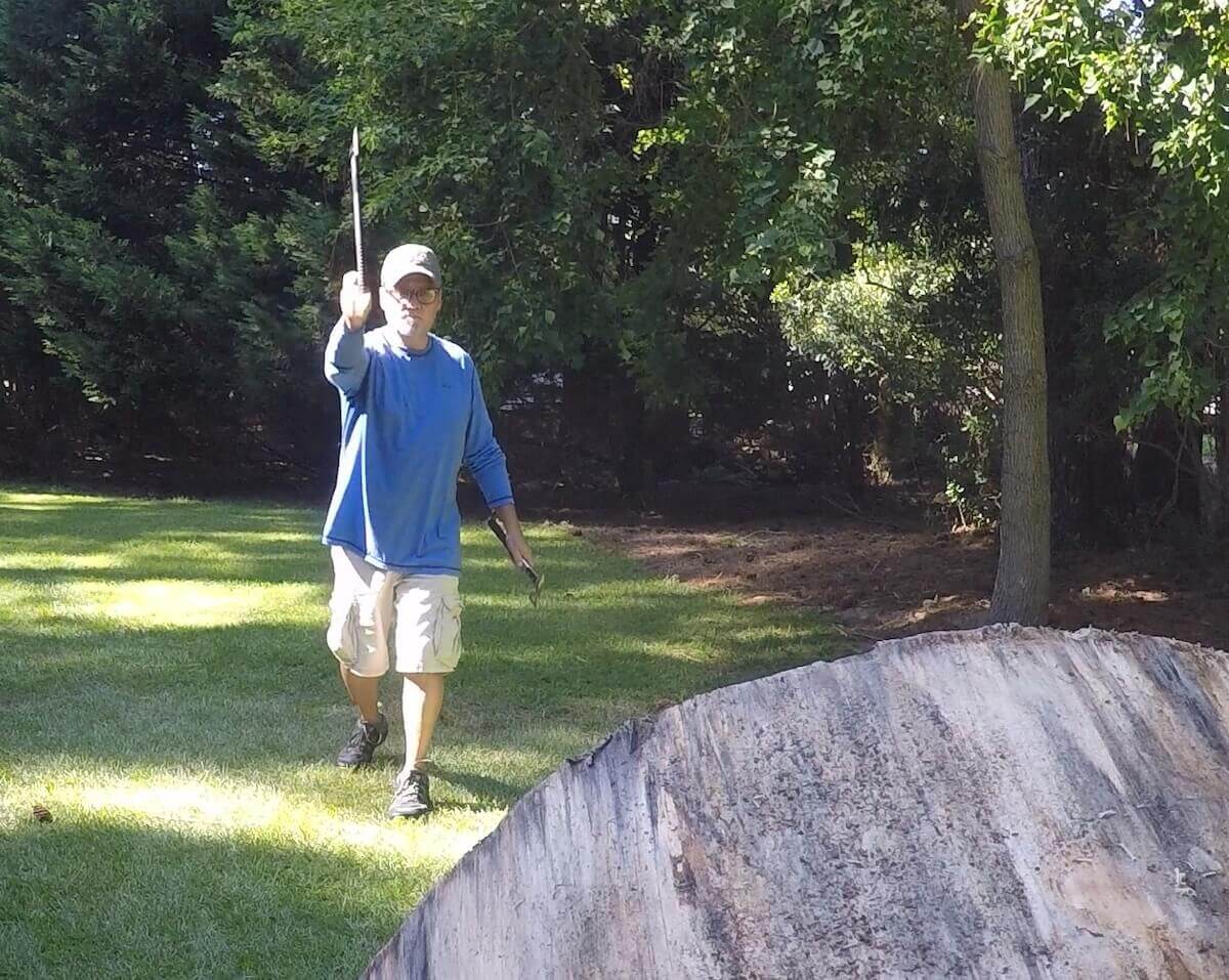 Man throwing tomahawk towards wood stand