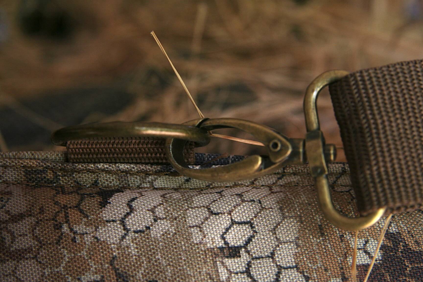 Closeup on brass hardware for gun case strap