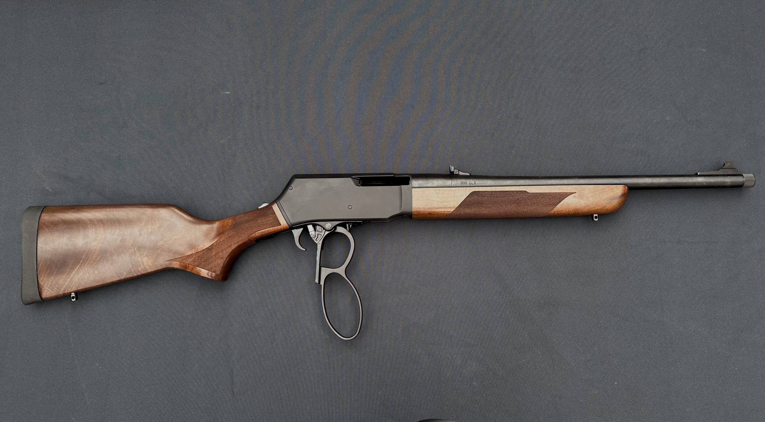 a lever action rifle lays on the table.