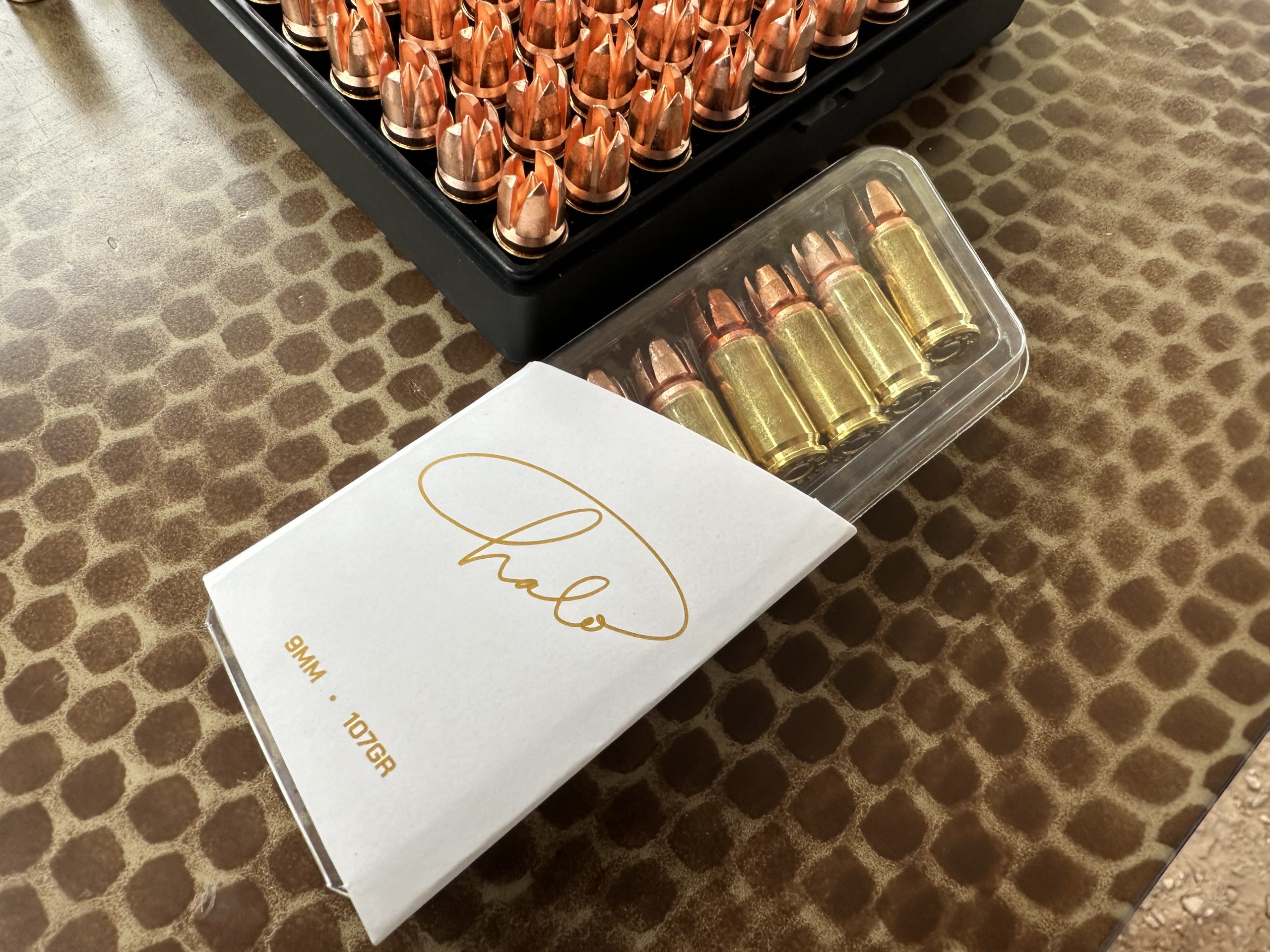 A box of bullets is desplayed on a table. 