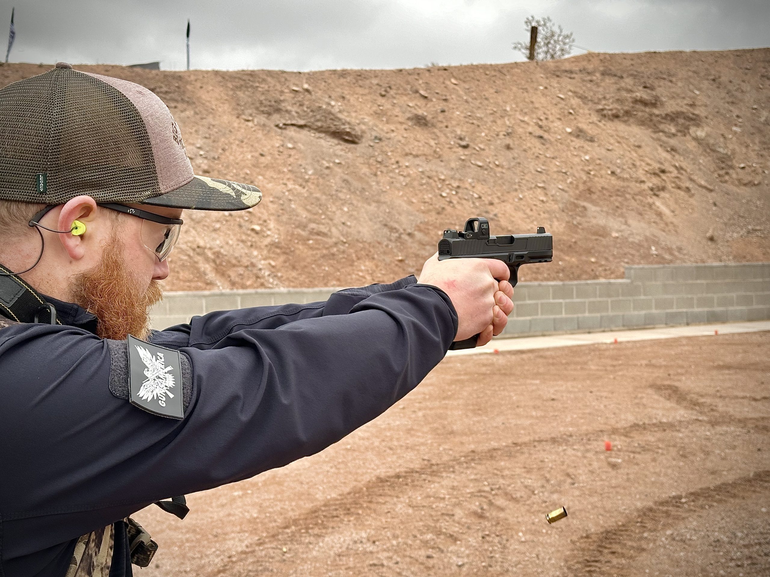 A man is shooting a pistol at the gun range.