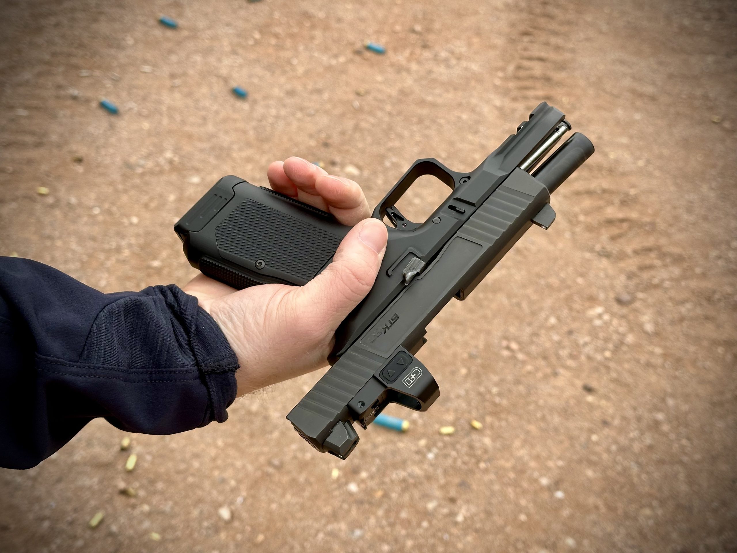 A man holds a pistol at the gun range.