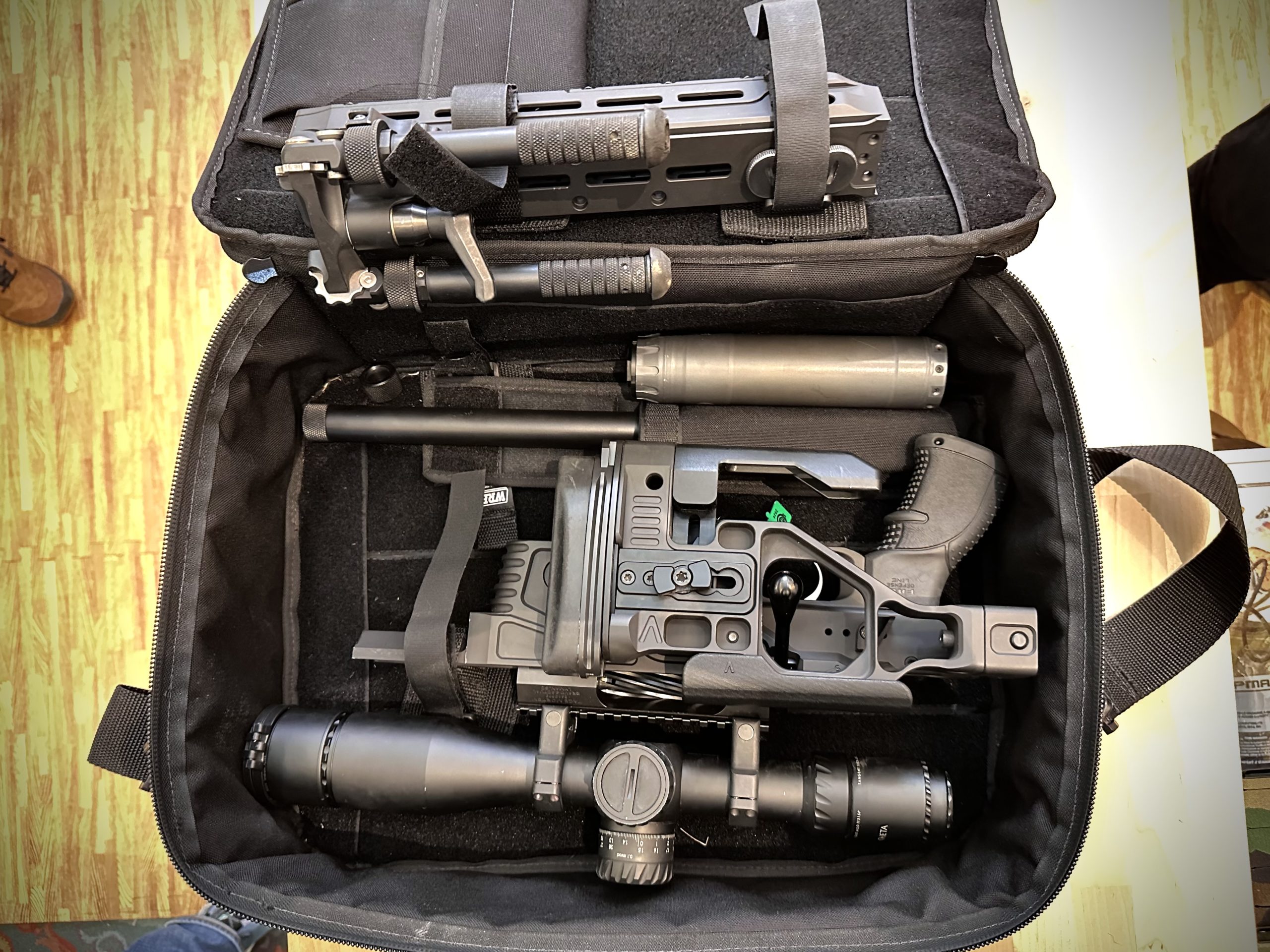 A rifle is taken apart and lies in a laptop case.