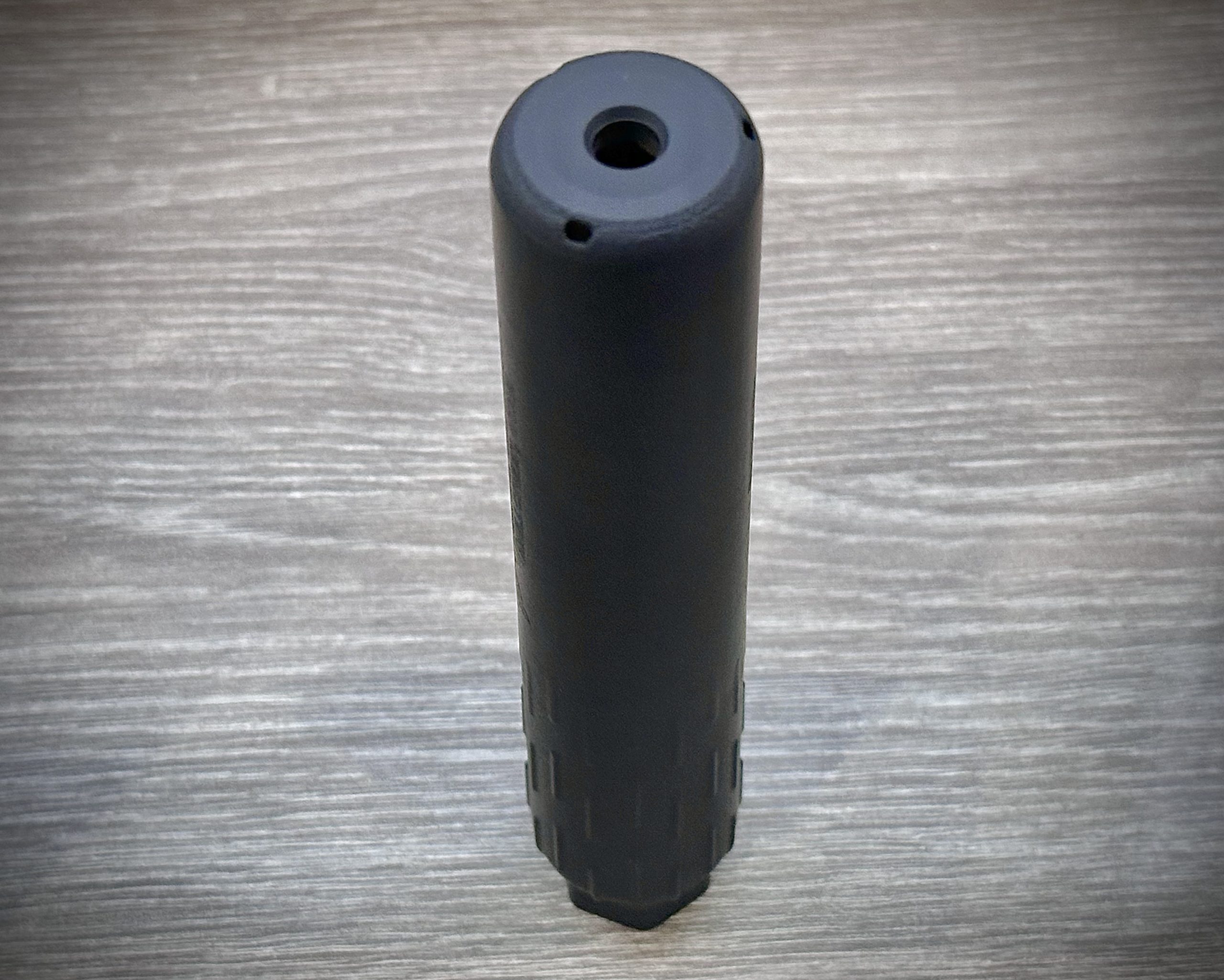 a suppressor sits on a table. 