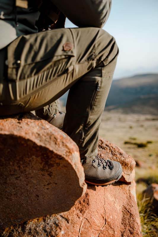 Hunter sitting on red rock with Dedito Luca boots