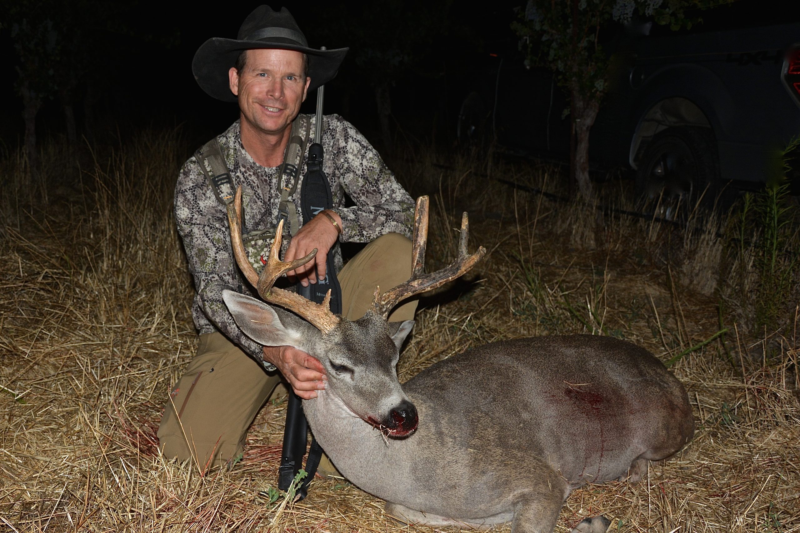 Hunter with Columbian Blacktail buck in the dark